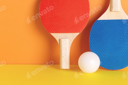 Preview: Red and blue rackets and white ball on orange background.