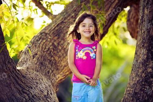 Preview: Smiling young girl standing on tree branches