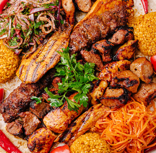 Preview: Flavorful mixed grill platter with meats and vibrant sides at a restaurant