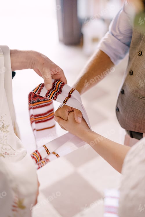 Preview: Priest ties a towel on the hands of the bride and groom