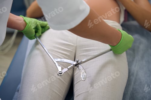 Preview: Partial of gynecologist measuring pregnant woman with obstetric pelvis gauge