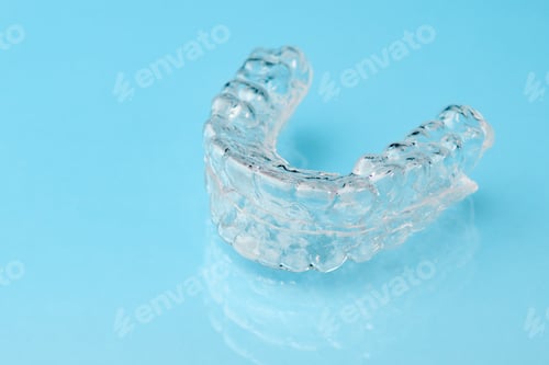 Preview: Close up invisible aligners on the blue background with copy space. Plastic braces dentistry