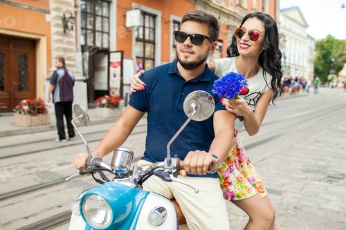 Preview: young beautiful hipster couple riding on motorbike city street