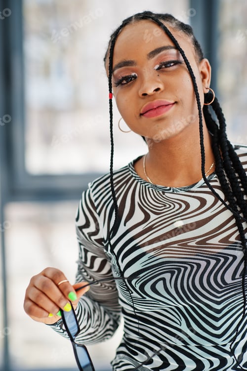 Preview: Afro woman in zebra dress posed indoor. Stylish portrait of african american model.