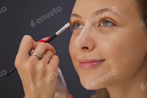 Preview: Female makeup artist makes up cute beautiful young woman in beauty salon