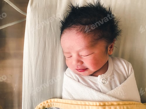 Preview: Infant Sleeping Peacefully Swaddled in a Hospital Bed