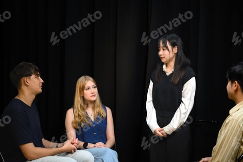 Preview: Young woman standing and sharing during a psychotherapy group session