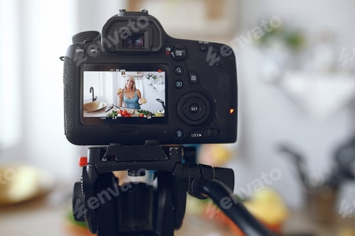 Preview: Beautiful and sporty girl in a kitchen recording a video