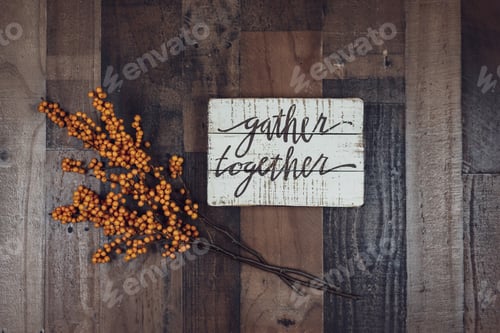 Preview: Gather together sign and stems of orange berries on rustic wood background