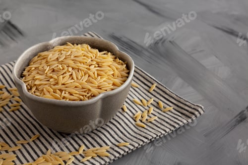 Preview: Raw Organic Orzo Pasta in a Bowl, side view. Copy space.