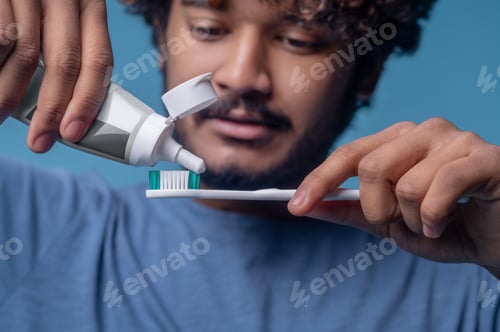 Preview: Concentrated man preparing for the tooth-brushing procedure
