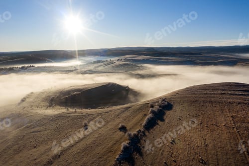 Preview: Flying over hills in mystic foggy winter morning. Aerial view by drone