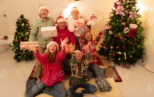 Preview: Merry Christmas and Happy Holidays! Cheerful family celebrating Christmas at home.