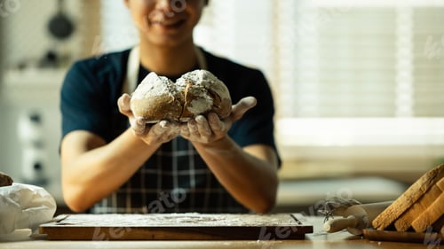Preview: Image of male baker hands holding traditional leavened sourdough bread.