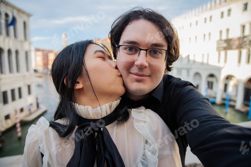 Preview: Girlfriend kisses her boyfriend on the cheek while on vacation in Venice on the Rialto bridge
