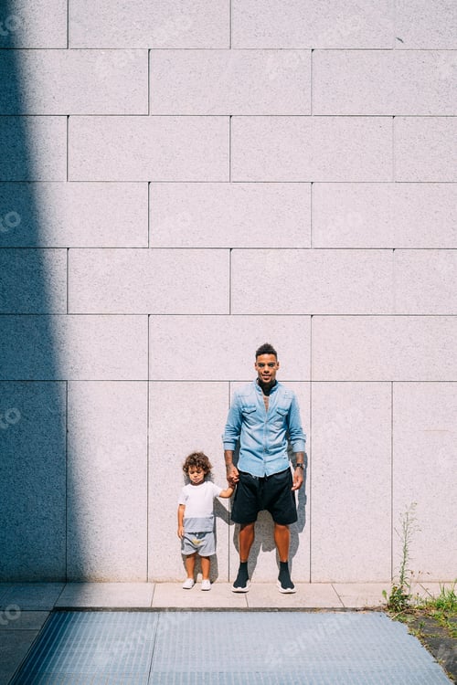 Preview: Father and son standing against concrete wall