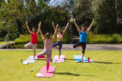 Preview: Female instructor teaching yoga to men and woman in park