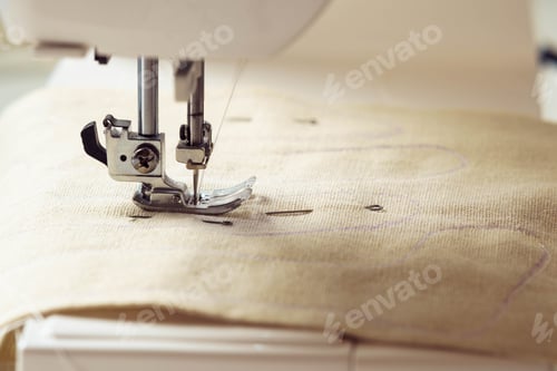 Preview: Close up beige soft fabric textile pattern with stitch contour on sewing machine needle plate under