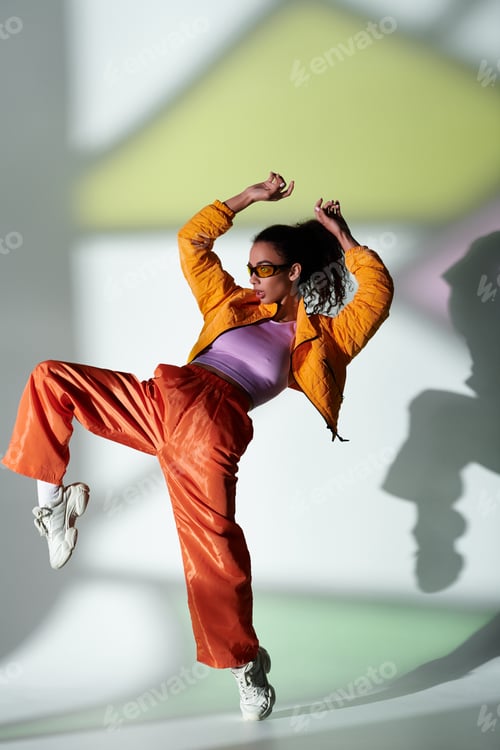 Preview: Stylish woman in yellow jacket and orange pants