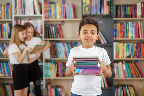 Preview: Afro american child boy choosing books in school library. Benefits of everyday reading.