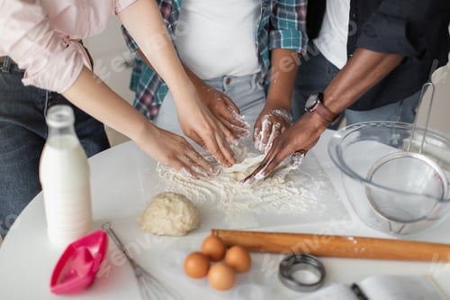 Preview: Close up top cropped view of hands of multiethnic parents teaching their mixed race daughter to