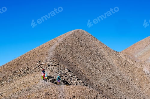 Preview: Group of hikers climbing stony mountains