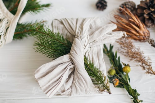 Preview: Stylish christmas gifts wrapped in linen fabric with green branch