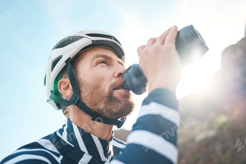 Preview: Cropped shot of a handsome mature man taking a water break while cycling outdoors