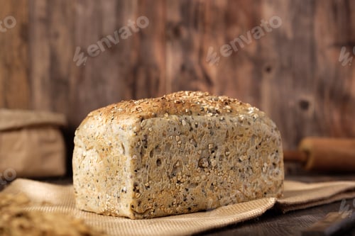 Preview: whole wheat baking bread with grains for healthy eating on wood table in kitchen