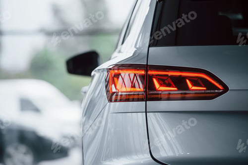 Preview: Red color lighting. Particle view of modern luxury white car parked indoors at daytime