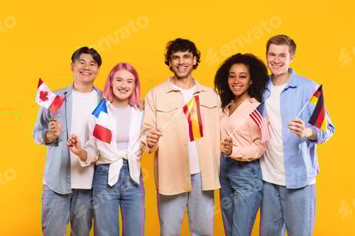 Preview: Happy multiracial people holding different countries flags and smiling at camera, standing on yellow