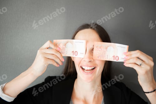 Preview: happy woman hides her eyes behind euro banknotes