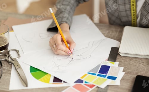 Preview: Fashion designer drawing sketches for clothes in atelier