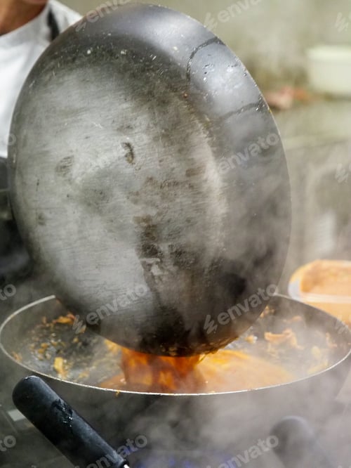 Preview: chef cooking sauce in a pan in professional restaurant catering kitchen