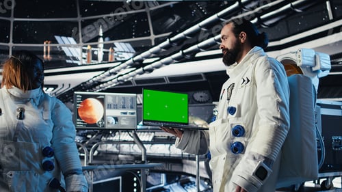 Preview: Astronauts check human expansion in space mission logs on mockup laptop