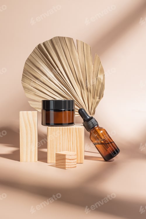 Preview: close up of collagen cream and beauty oil in amber glass jar and dry palm leaf on beige backgroun