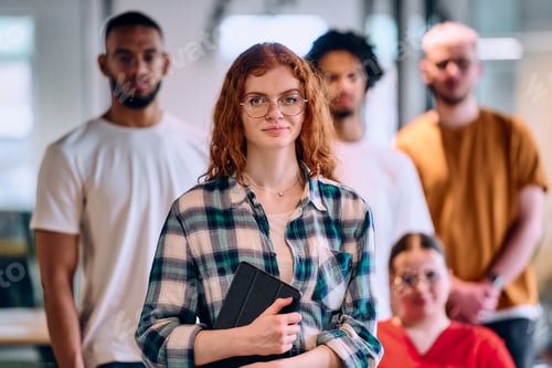 Preview: A diverse group of young business people walking a corridor in the glass-enclosed office of a modern