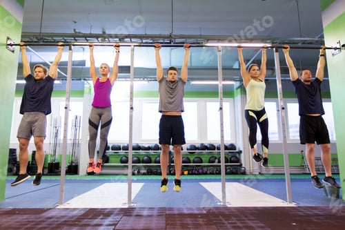 Preview: group of people hanging at horizontal bar in gym