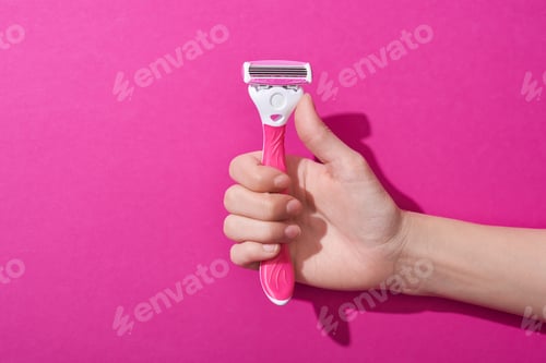 Preview: cropped view of woman holding razor on pink background