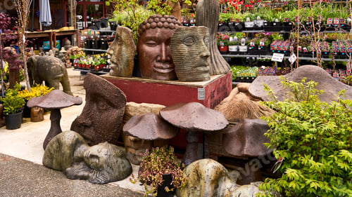 Preview: Numerous garden ornaments and bedding plants for sale at a garden center.