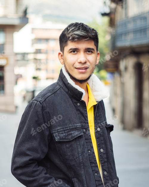 Preview: Latino man on the street with hands in jacket pocket looking at camera