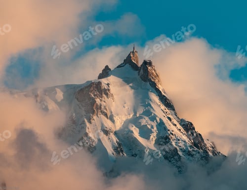 Preview: Picture of Aiguille du Midi covered in the snow and the fog under a blue sky in the French Alps
