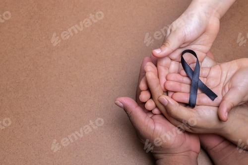 Preview: hands holding black ribbon, melanoma cancer, chocolate background