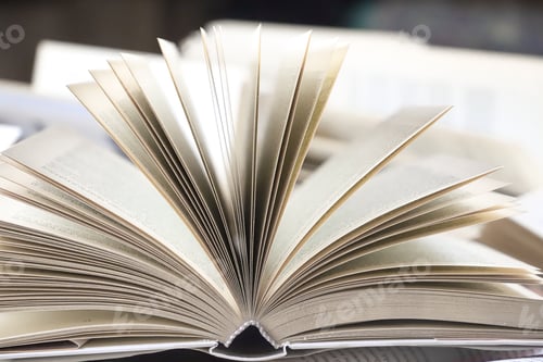 Preview: stack of books, close up. Open book on the table in library. Back to school concept. Open book on ta