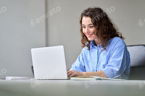 Preview: Young happy business woman employee sitting at office desk working on laptop.