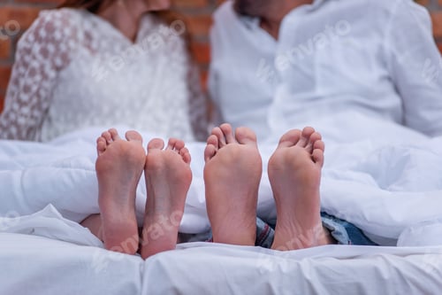 Preview: From under the white she covered two pairs of feet of couple in love. The newlyweds are having fun