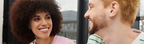 Preview: Smiling friends share moments of joy while packing boxes for a move in a modern apartment