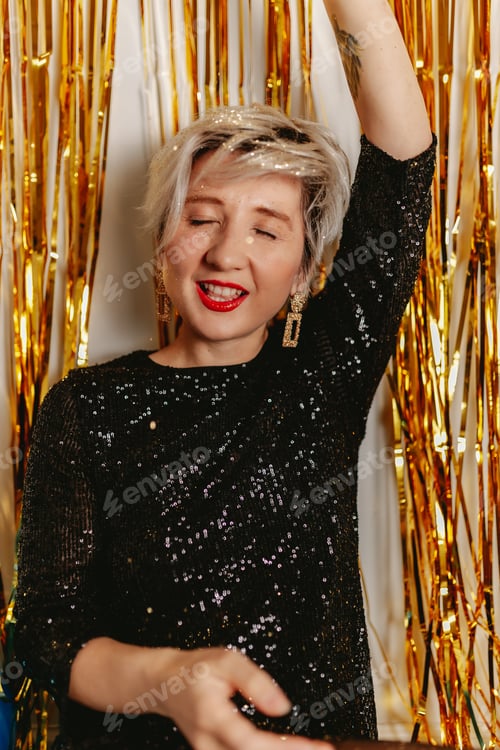 Preview: Young millennial blonde woman celebrating New Years Eve. Glitter sparkling confetti. Gold party fun