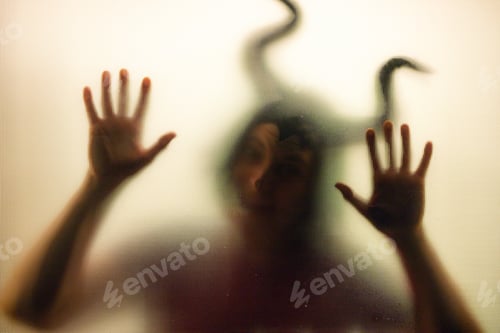 Preview: Horror, halloween background - Shadowy figure with horns behind the glass