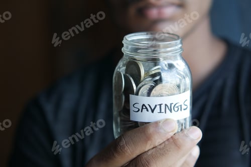 Preview: Savings Jar Held by Person Wearing Dark Shirt